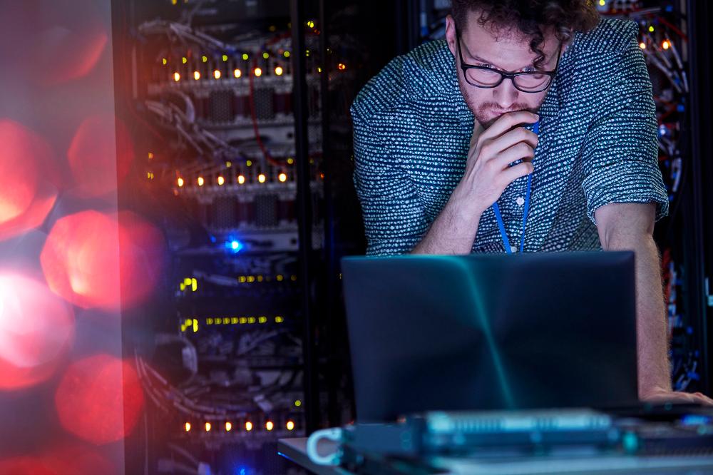 IT-freelancer der kigger på en bærbar i et serverrum