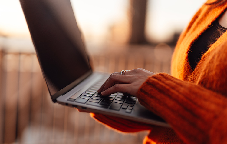 Current information on maintenance work & service hotlines Woman standing with her open laptop in both hands