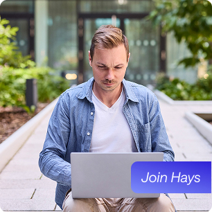 Medarbejder sidder i gården ved sin bærbare computer