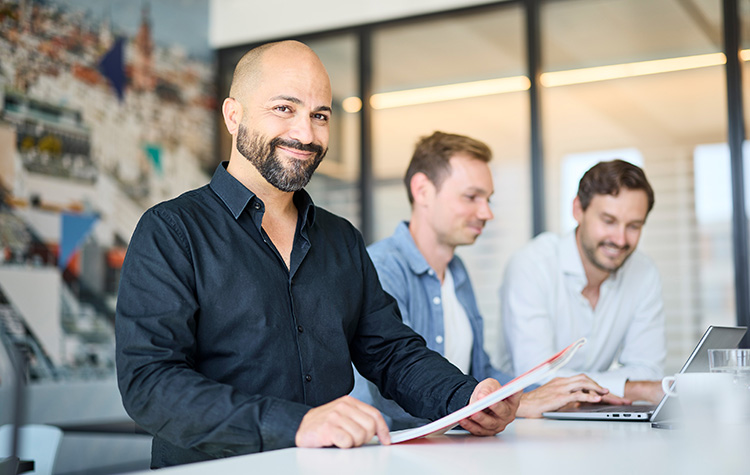 3 medarbejdere arbejder stående ved siden af hinanden