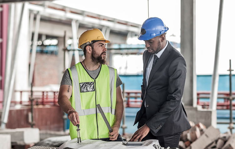 Businessman and construction worker discussing on site